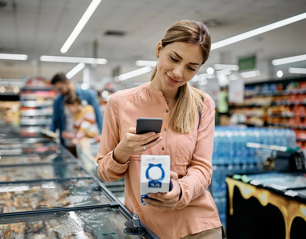 Consumator scanând un cod QR GS1 Digital Link în supermarket